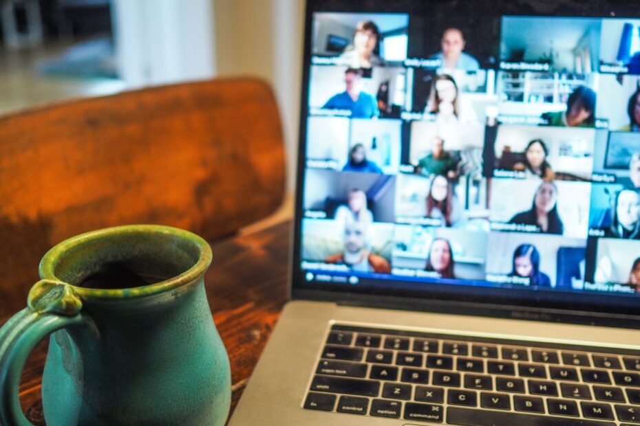 photo of a mug and a Macbook with a Zoom call featured onscreen